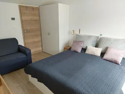 a bedroom with a blue bed and a blue chair at River Apartment in Bovec