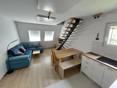 a living room with a blue couch and a staircase at River Apartment in Bovec