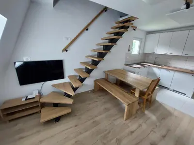 a staircase in a room with a table and a tv at River Apartment in Bovec