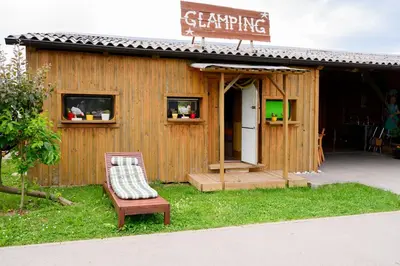 a small building with a chair in front of it at GLAMPING HOUSE RANČ LUŽE in Luže