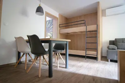 a dining room with a table and chairs and a bunk bed at Apartments with Private Saunas - WELLNESS Gobi in Podčetrtek