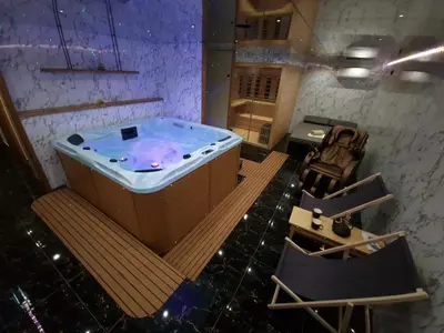 a hot tub in a room with a table and chairs at Apartments with Private Saunas - WELLNESS Gobi in Podčetrtek