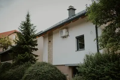 a white house with a tree in front of it at Haloze na dlani - Haloze in your hand, hiša s pogledom na hribe - a house vith a view of hills in Gruškovec