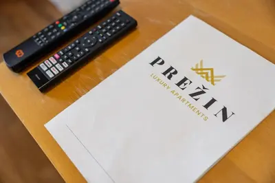 a remote control sitting on a table next to a paper at Luxury apartments Prežin in Pohorje