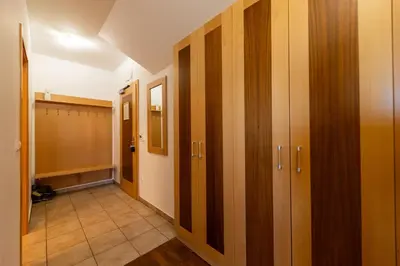 a hallway with wooden doors and a tile floor at Luxury apartments Prežin in Pohorje
