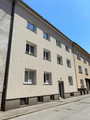 a large brick building with windows on a street at Boennium Apartments Green Oasis in Ljubljana