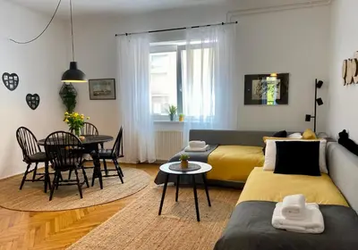 a living room with a couch and a table at Boennium Apartments Green Oasis in Ljubljana