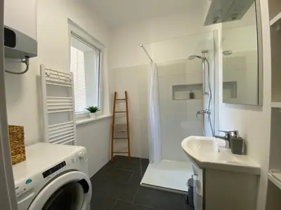 a bathroom with a washing machine and a sink at Boennium Apartments Green Oasis in Ljubljana