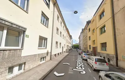 a street with cars parked on the side of a building at Boennium Apartments Green Oasis in Ljubljana