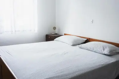 a bedroom with a white bed with two pillows at Roja House in Soča