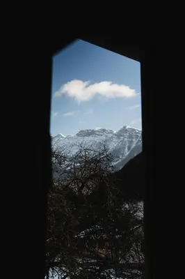 a view of a snow covered mountain from a window at Roja House in Soča
