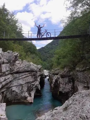 a man standing on a bridge over a river at Roja House in Soča