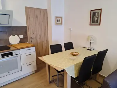 a kitchen with a table with chairs and a counter at Apartma Dora Bovec in Bovec
