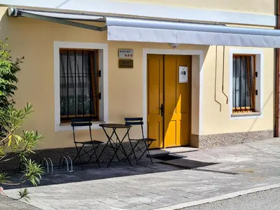 a table and chairs in front of a building with a yellow door at Apartma Dora Bovec in Bovec