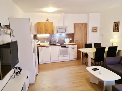 a kitchen and a living room with a table and chairs at Apartma Dora Bovec in Bovec