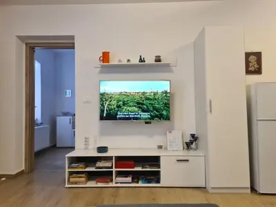 a living room with a tv on a wall at Apartma Dora Bovec in Bovec