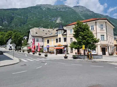 a street in a town with a mountain in the background at Apartma Dora Bovec in Bovec
