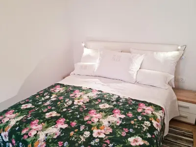 a bedroom with a bed with a floral bedspread at Apartma Dora Bovec in Bovec
