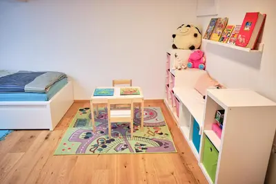 a bedroom with a bunk bed and a desk and a rug at Apartma La Casa in Radovljica