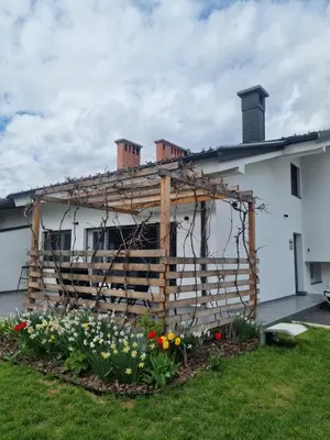 a house with a wooden fence in the yard at Apartma La Casa in Radovljica
