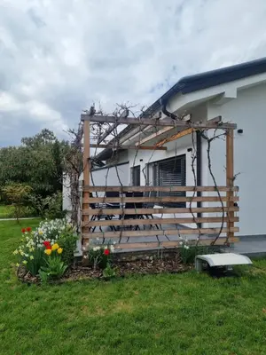 a house with a fence and flowers in the yard at Apartma La Casa in Radovljica