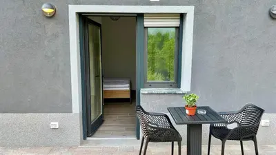 a patio with a table and two chairs and a window at Panorama rooms in Bovec
