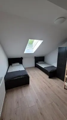 a attic room with two beds and a window at Apartma Krupa in Gradac
