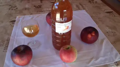 a bottle of apple cider and a glass of wine at Apartma Krupa in Gradac