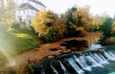 a waterfall in front of a house and a building at Apartma Krupa in Gradac