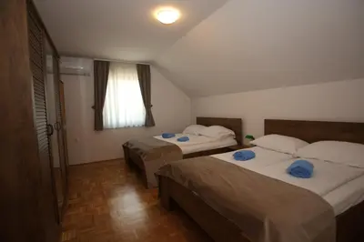 a bedroom with two beds and a window at Apartments Vila Leska in Zgornji Leskovec