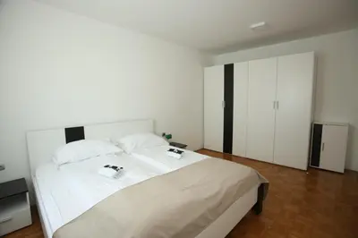 a bedroom with a large white bed with two pillows at Apartments Vila Leska in Zgornji Leskovec