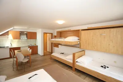 a room with two bunk beds and a kitchen at Apartments Vila Leska in Zgornji Leskovec
