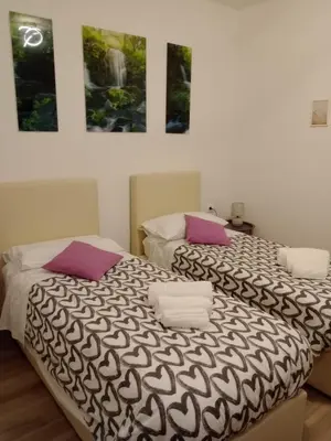 a bedroom with two beds and two pictures on the wall at Shamarè Resort & Wellness Spa in Hrpelje