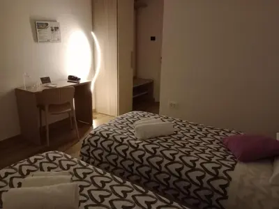 a bedroom with a bed and a desk and a table at Shamarè Resort & Wellness Spa in Hrpelje