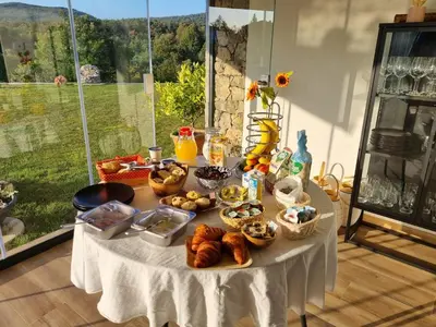 a table with bread and other food on it at Shamarè Resort & Wellness Spa in Hrpelje