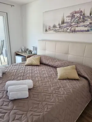 a bedroom with a large bed with two pillows at Shamarè Resort & Wellness Spa in Hrpelje