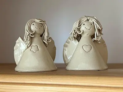 two little angel figurines sitting on a shelf at Apartma Ana in Manca in Begunje na Gorenjskem