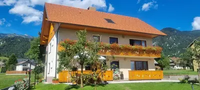 a house with flowers on the side of it at Apartma Ana in Manca in Begunje na Gorenjskem