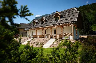 a large house with a gambrel roof at NATUR BAJTA in Solčava