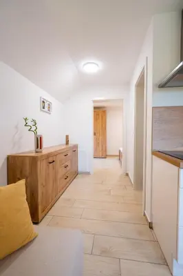a living room with a wooden floor and a hallway at Na-Ture Apartments in Zgornje Gorje