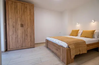 a bedroom with a large bed and a wooden cabinet at Na-Ture Apartments in Zgornje Gorje