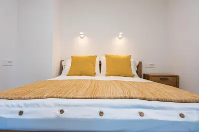 a bedroom with a large bed with yellow pillows at Na-Ture Apartments in Zgornje Gorje