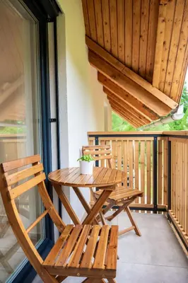 a wooden table and two chairs on a porch at Na-Ture Apartments in Zgornje Gorje