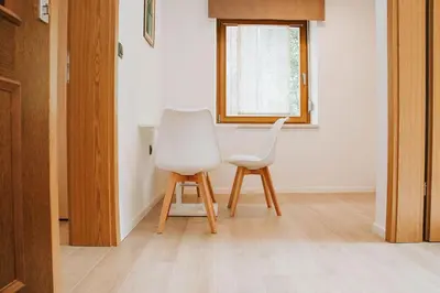a white chair sitting next to a table in a room at Apartmaji URŠIČ in Kobarid