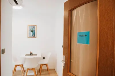 a door with a sign on it next to a table and chairs at Apartmaji URŠIČ in Kobarid
