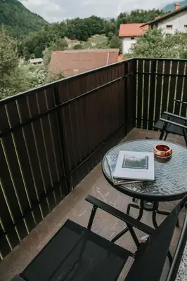 a patio with a table and chairs on a balcony at Apartmaji URŠIČ in Kobarid