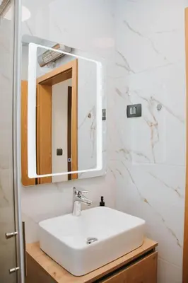 a bathroom with a white sink and a mirror at Apartmaji URŠIČ in Kobarid