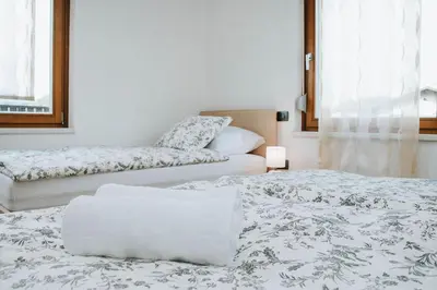 a room with two beds with white sheets at Apartmaji URŠIČ in Kobarid