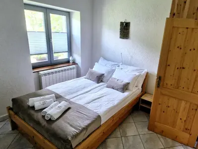 a bedroom with a bed with two towels on it at GUESTHOUSE Idila pod Nanosom in Senožeče
