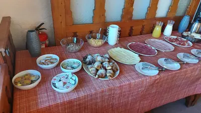 a table with plates and bowls of food on it at Tičarjev Dom at Vrsic pass in Soča